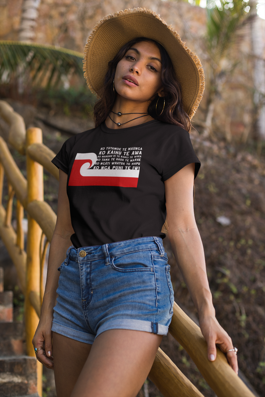 beautiful maori woman wearing blue shorts, a tan hat and a custom pepeha tee by Mana Ake