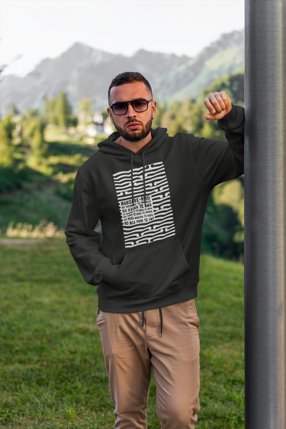 Tane man wearing a custom koru pepeha hoodie with grass in the background