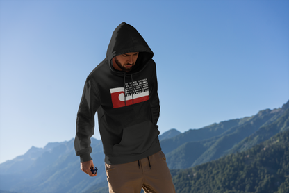 Maori tane wearing a custom pepeha hoodie by Mana Ake, brown pants on top of a mountain 